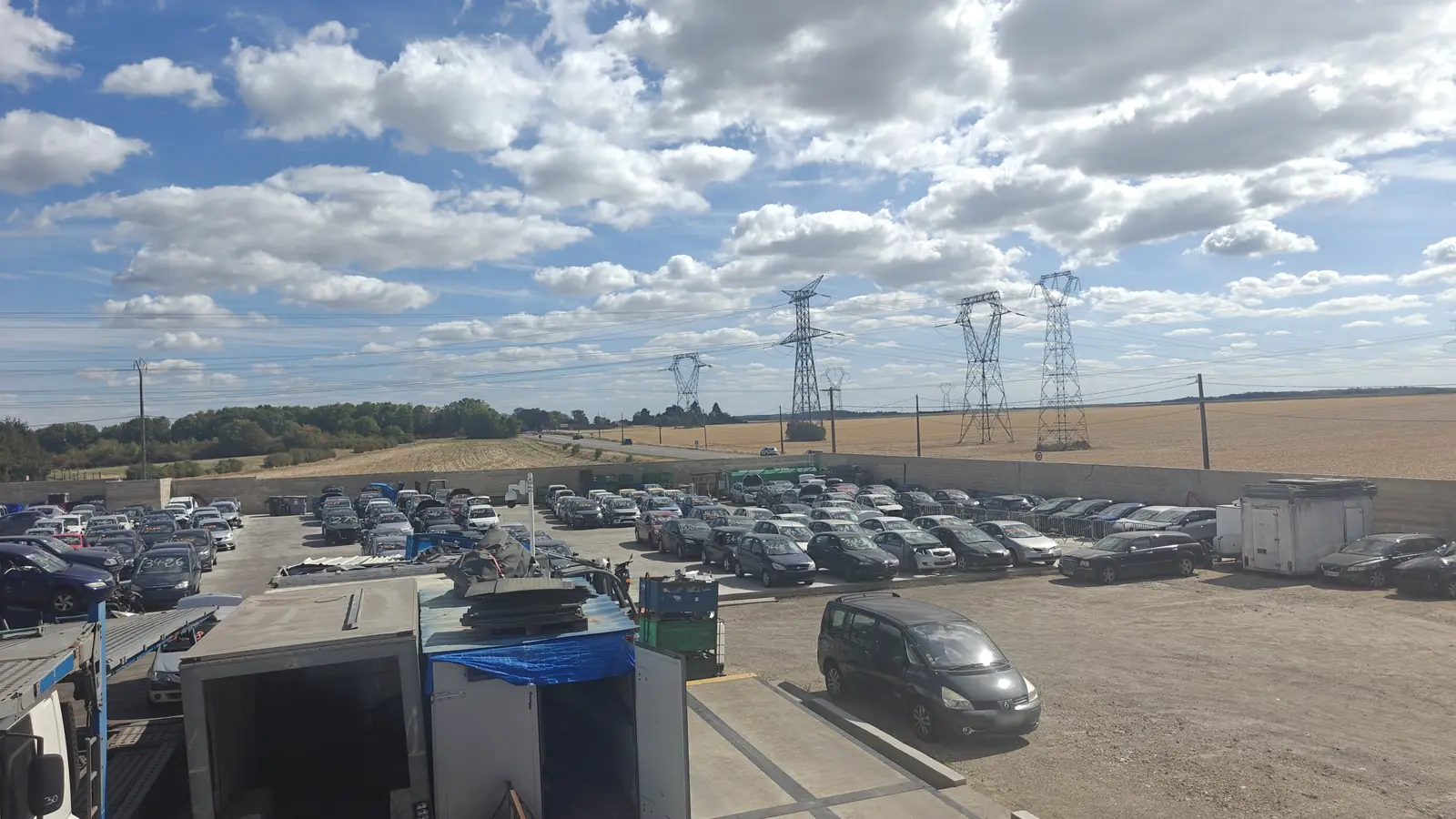 Vue en hauteur de notre casse automobile à Moret-Loing-et-Orvanne (77) : voitures en rangées entre murs de béton et champs