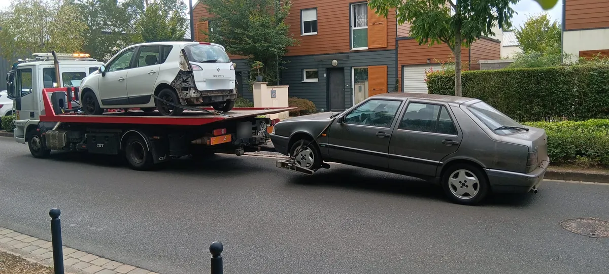 Épaviste à Chessy (77) : Renault Scénic accidenté chargé sur le camion plateau et ancienne berline remorquée au lève-roues