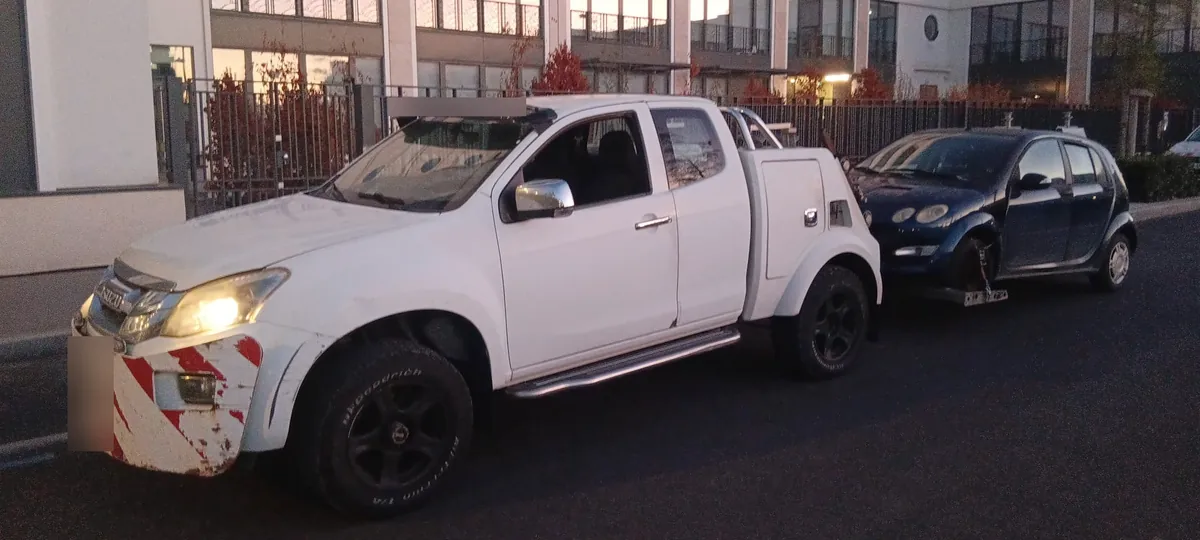 Épaviste près de Paris : notre dépanneuse pick-up blanche remorque au lève-roues une citadine bleu foncé