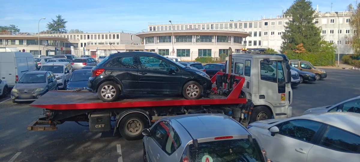 Camion plateau de notre épaviste agréé VHU devant des immeubles de bureaux à Évry-Courcouronnes, Essonne (91)
