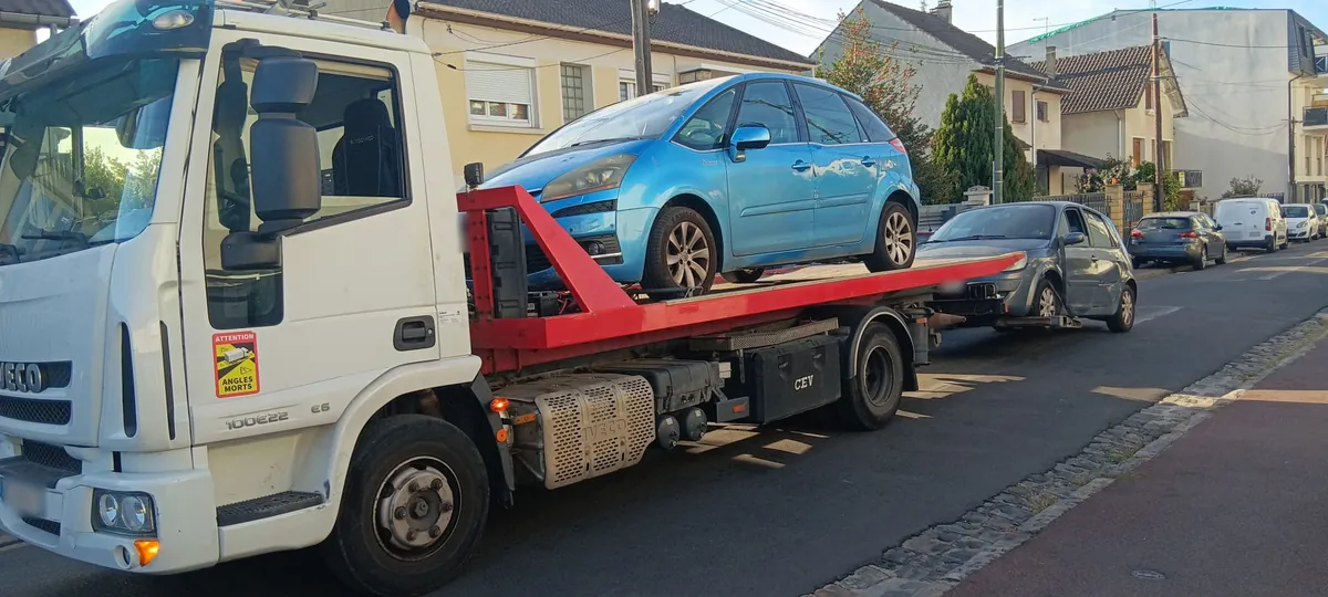 Dépanneuse plateau de notre épaviste agréé VHU chargée d'une C4 Picasso, Scénic en remorque, à Tremblay-en-France (93)