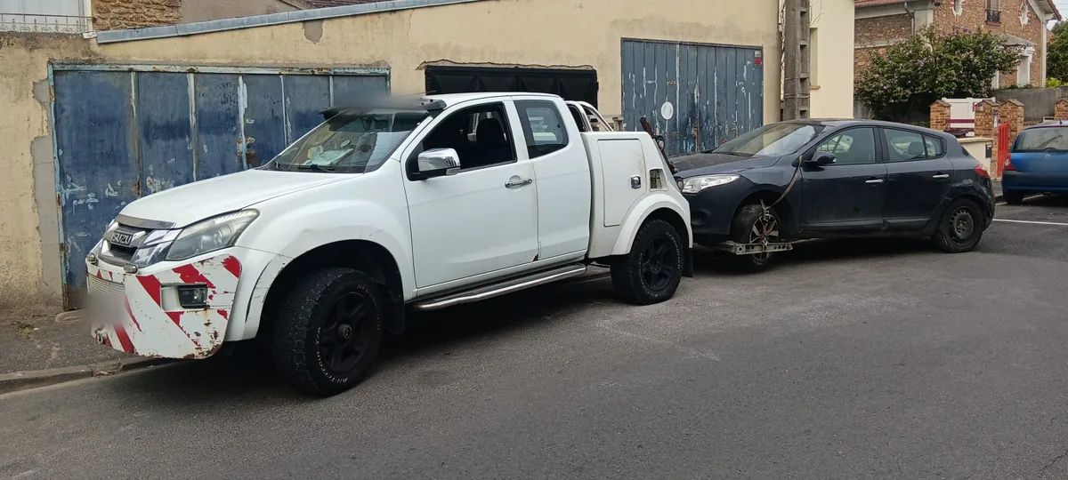 Dépanneuse pick-up de notre épaviste agréé VHU remorquant une épave dans une rue de Corbeil-Essonnes (91)